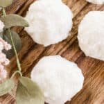 Moisturizing bath truffles on a wooden trying board.