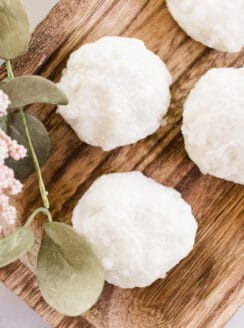 Moisturizing bath truffles on a wooden trying board.