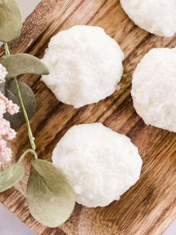 Moisturizing bath truffles on a wooden trying board.
