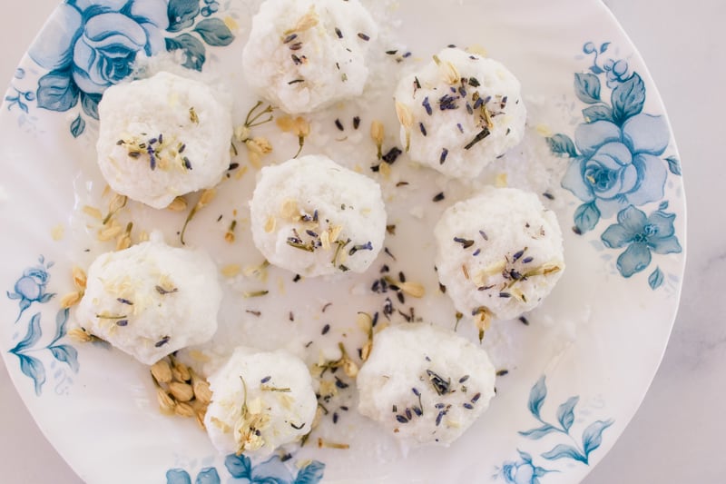 Several bath truffles on a plate decorated with dried flowers.