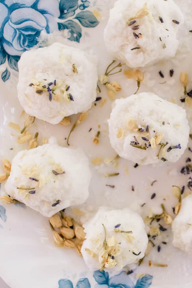 A homemade bath truffles recipe on a plate decorated with dried flowers.