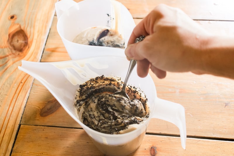 Stirring in the coffee grounds into the melted soap bar ingredients.
