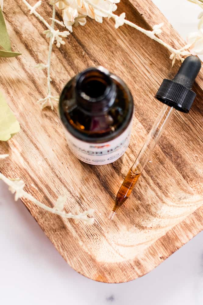 Lemon balm oil and dropper on a wooden board.