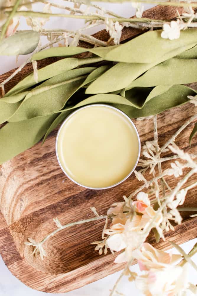 Lemon balm salve on a wooden board.