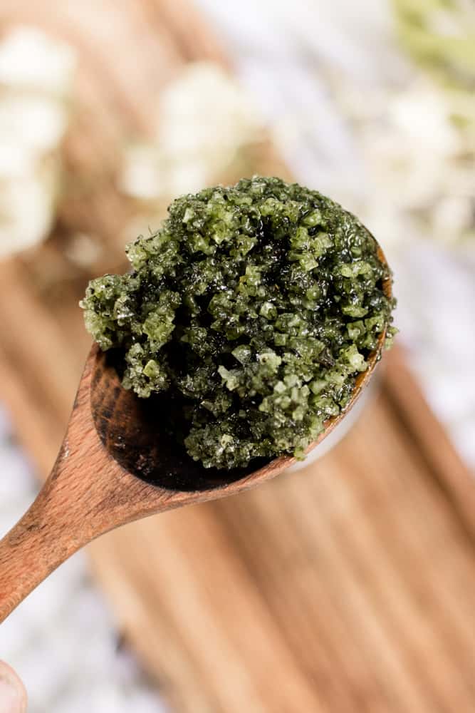Close up green tea matcha scrub on a wooden spoon. 
