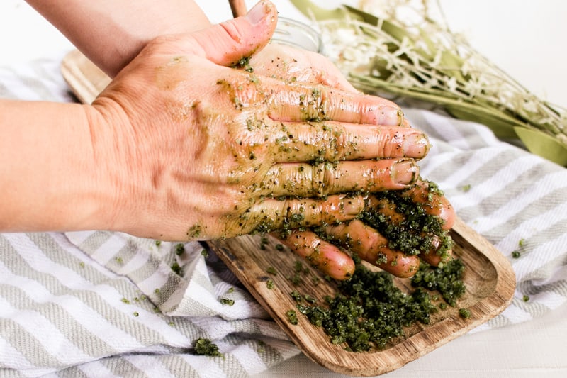 A pair of hands rubbing in green tea matcha scrub. 