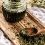 Matcha body scrub on a wooden beauty tray.