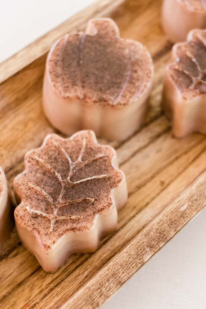 Pumpkin spice soap bars on a wooden board in different shapes for fall. 