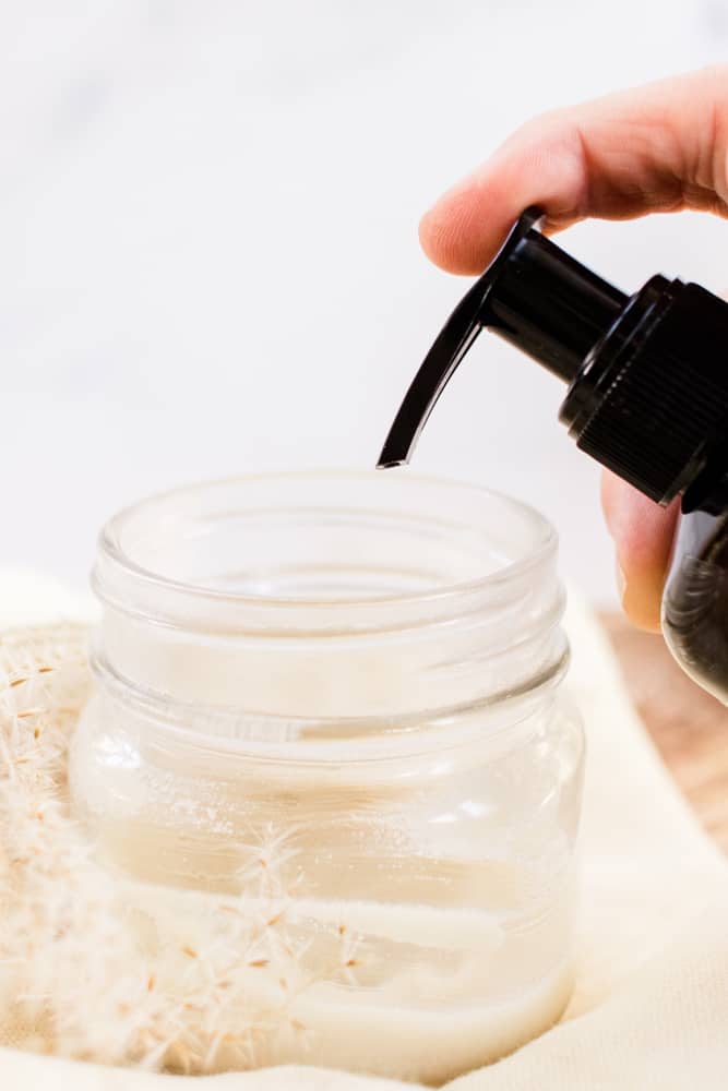 Wheat germ oil being squeezed into a glass jar. 