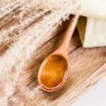 Organic wheat germ oil in a wooden spoon with dried wheat stem