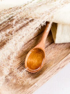 Organic wheat germ oil in a wooden spoon with dried wheat stem