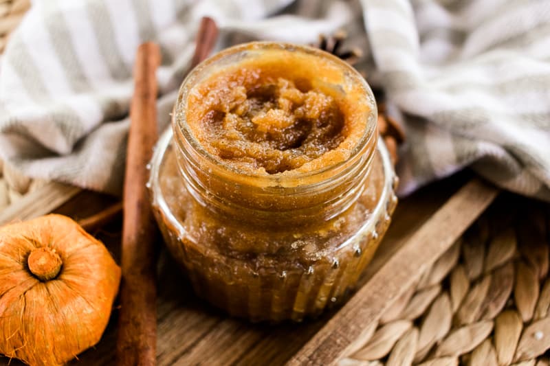 Fall body scrub in a glass jar with cinnamon sticks to the side. 