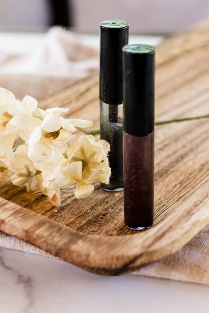 Two jars of DIY eyebrow gel on a wooden board. 