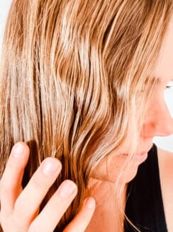 Running hands through wavy hair after applying homemade curl cream.