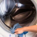 Wiping down the front seal of a washing machine.