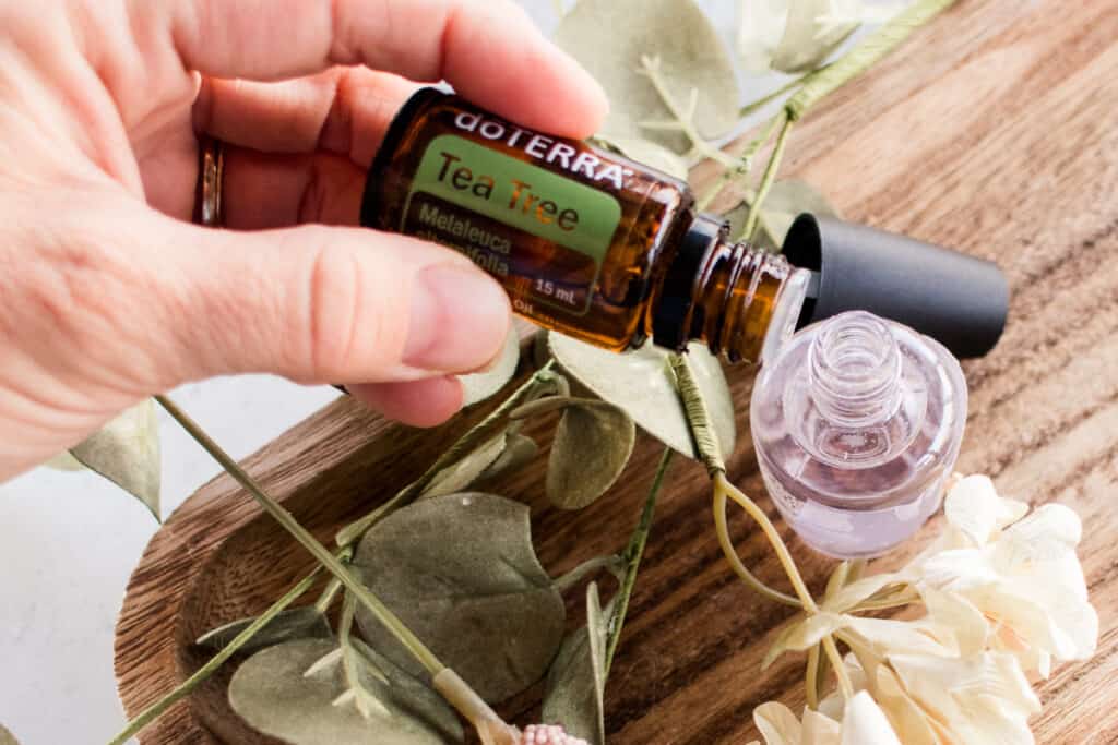 Essential oil being added to a bottle of diy cuticle oil. 