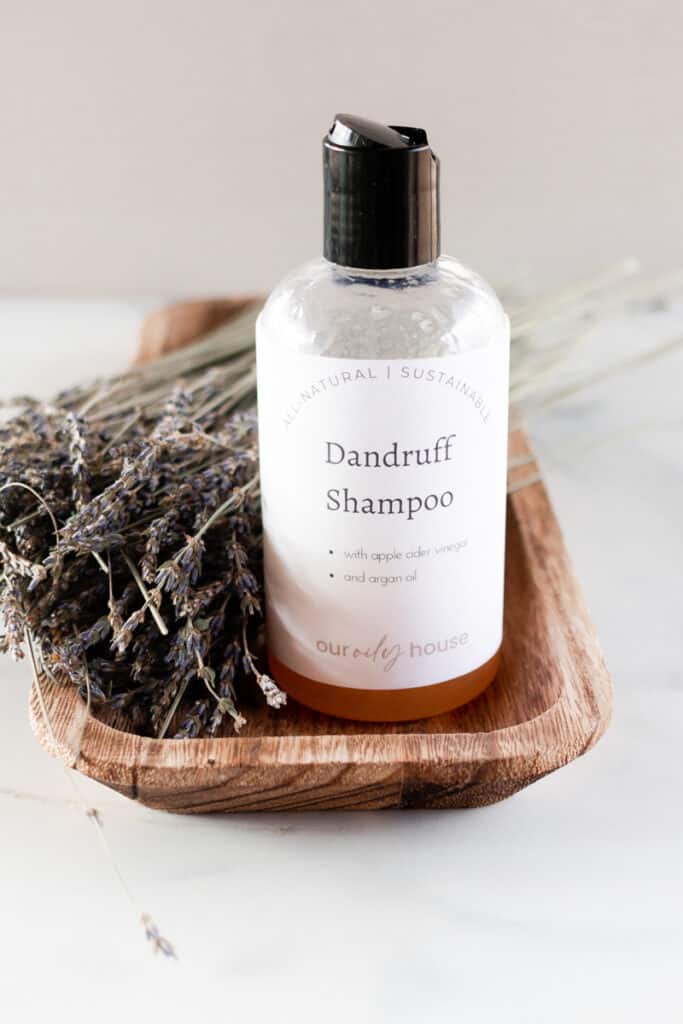 A bottle of homemade dandruff shampoo with sprigs of lavender. 