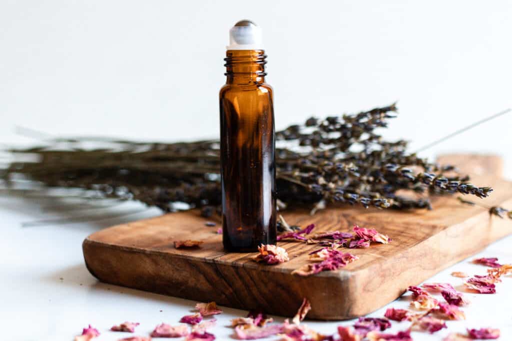 Essential oil roller bottle for wrinkles and aging skin with dried rose petals.