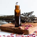 Essential oil roller bottle for wrinkles and aging skin with dried rose petals.