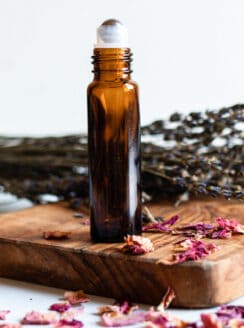 Essential oil roller bottle for wrinkles and aging skin with dried rose petals.