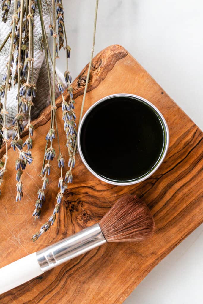 Close up of matcha face mask and make up brush on a wooden board. 