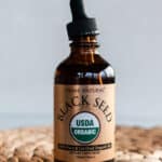Glass bottle of black seed oil to use for strengthening hair.