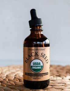Glass bottle of black seed oil to use for strengthening hair.