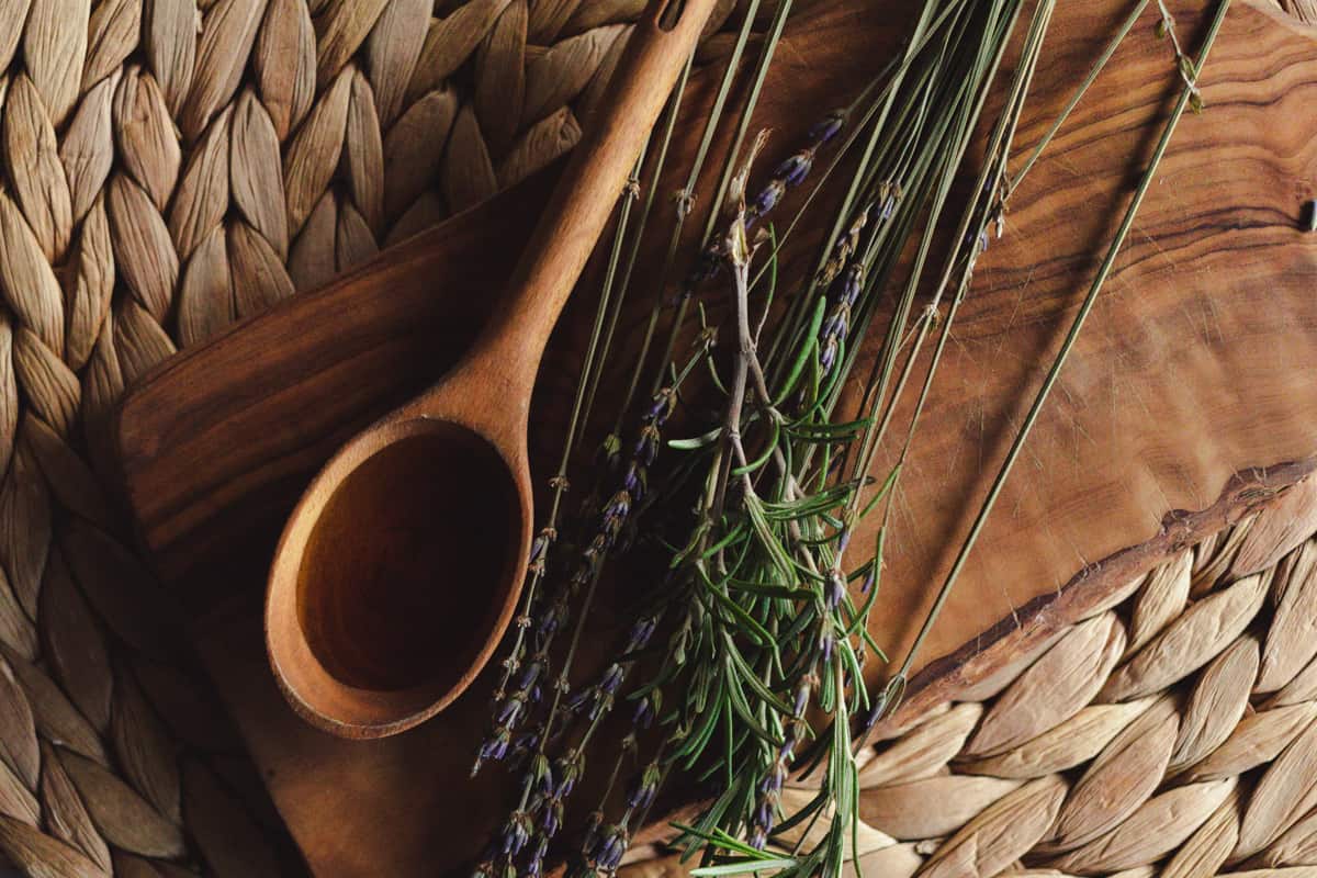 Black seed oil for hair in a  wooden spoon on a small board.