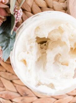 Natural body cream in a open top glass storage jar.