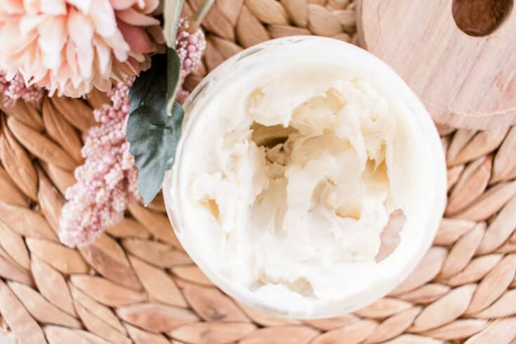 Natural body cream in a open top glass storage jar.