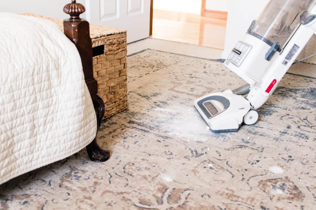 Vacuuming baking soda from a carpet. 