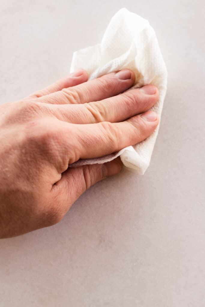 Wiping over a white marble stain with a soft cloth. 