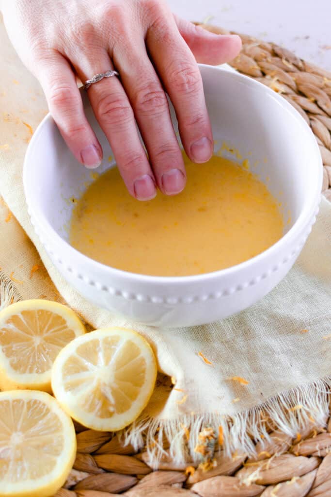 Dipping nails into all natural nail soak. 