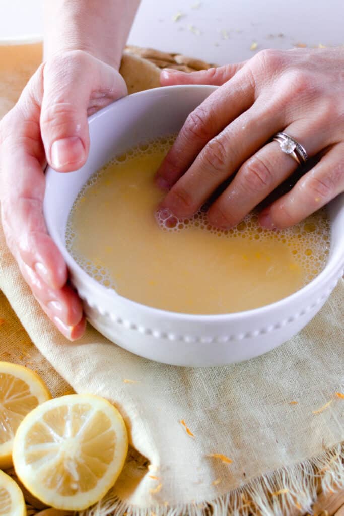 Dipping nails in a homemade nail soak. 