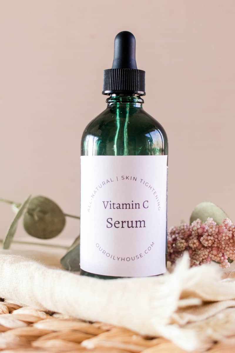 Homemade vitamin C serum in a glass dropper bottle with a homemade label on a decorative table.