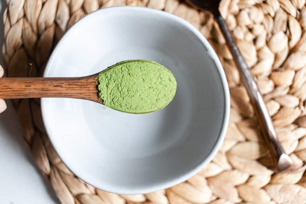 Adding matcha powder to a bowl.