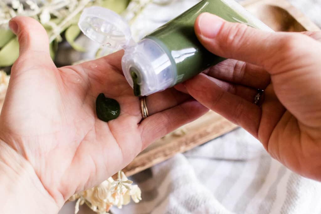 Squeezing gel face cleanser onto the hand.