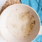 Odor fighting foot soak with dried chamomile flowers in a large bowl.