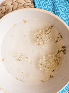 Odor fighting foot soak with dried chamomile flowers in a large bowl.