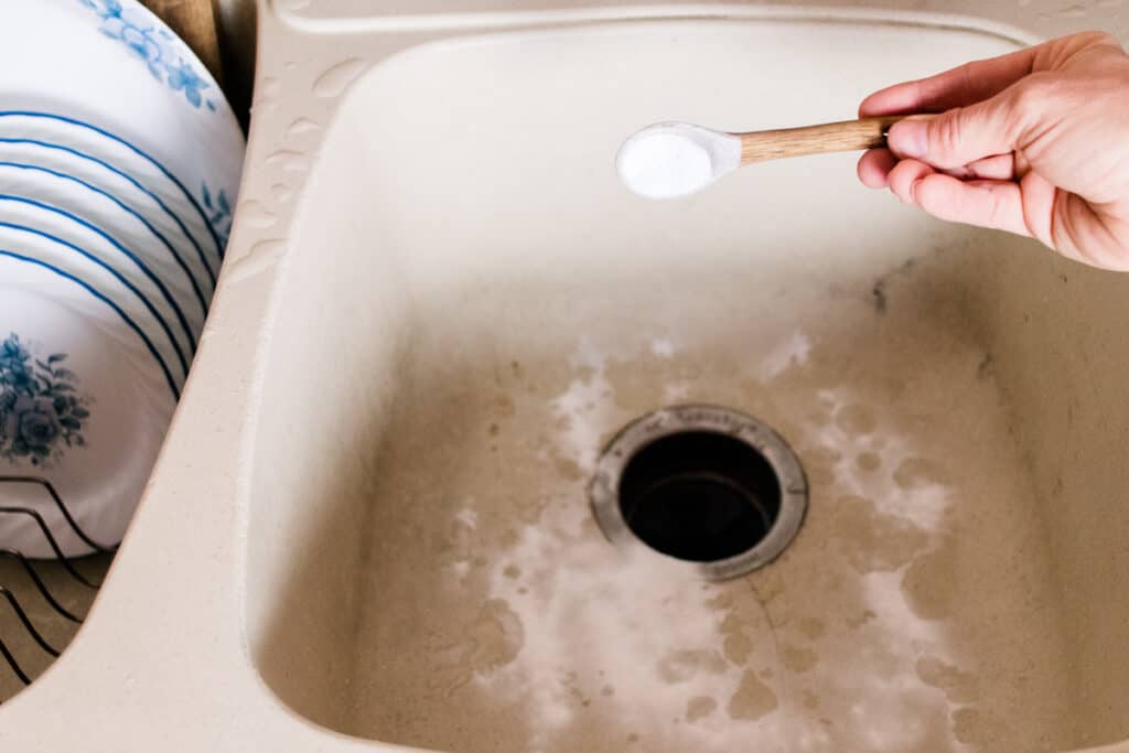 Sprinkling sink with baking soda.