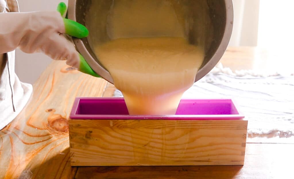 Pouring the melted soap into a soap mold to harden.