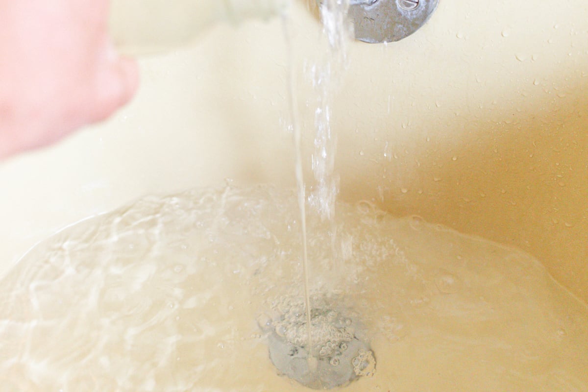 Filling the tub with hot water for a bubble bath.