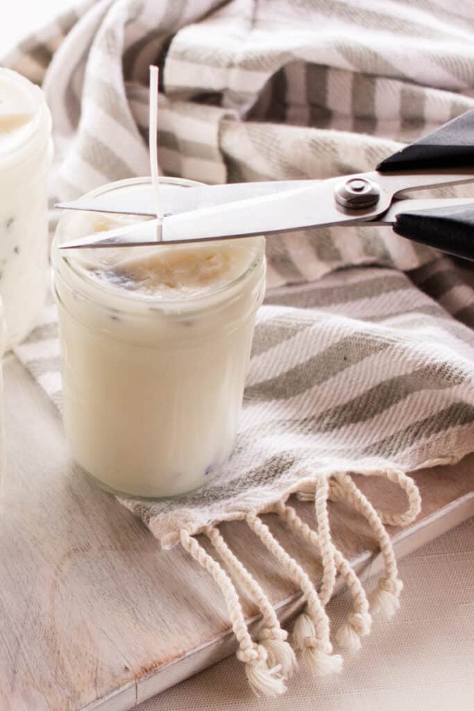 Cutting the wick of a mason jar candle. 