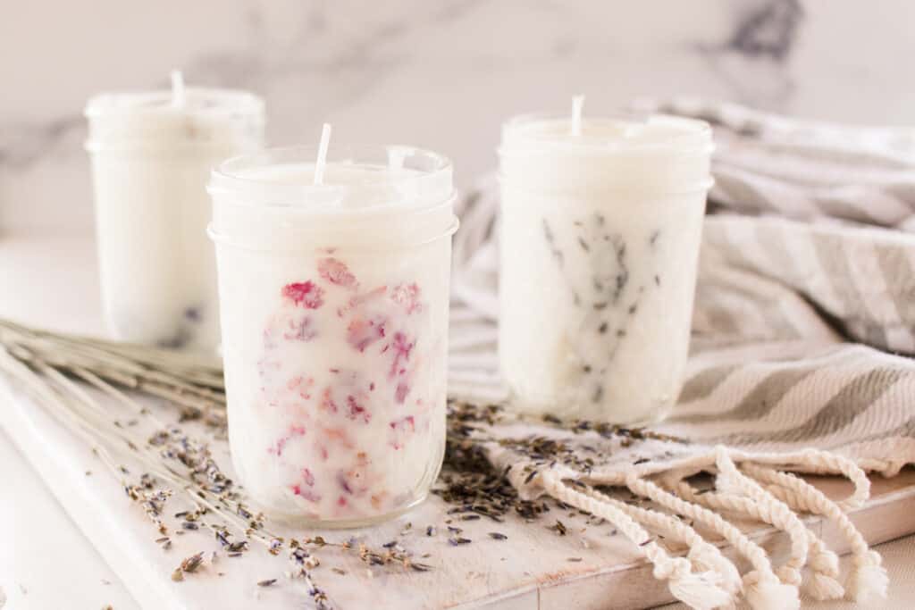 Mason jar candles on a cloth throw. 