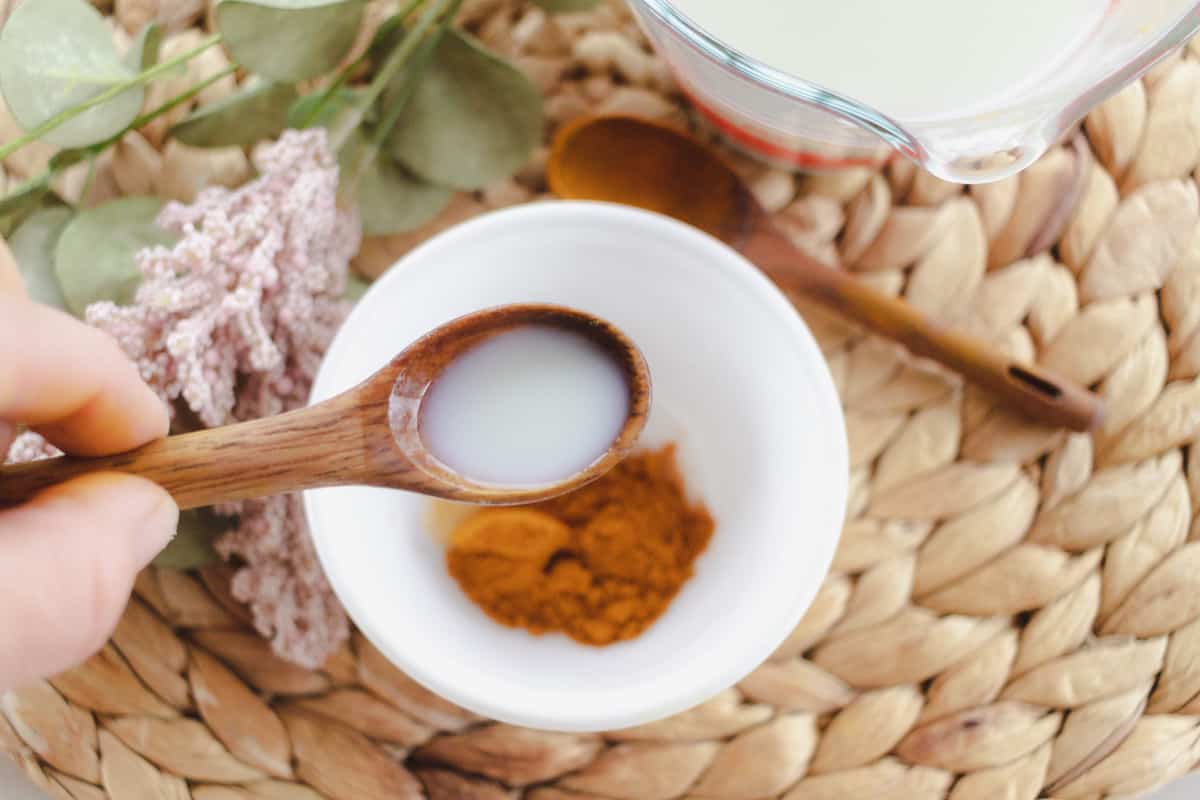 Mixing buttermilk and turmeric in a bowl.