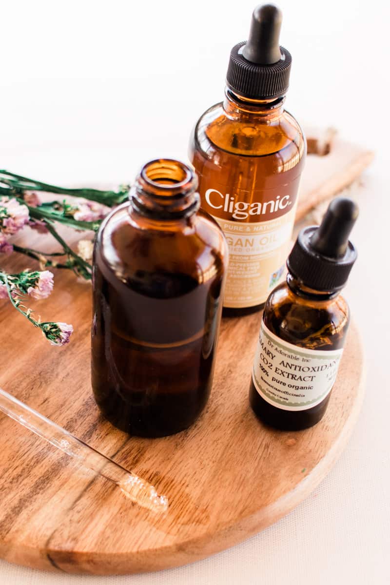 Ingredients for the cleansing oil lined out on a wooden table top.