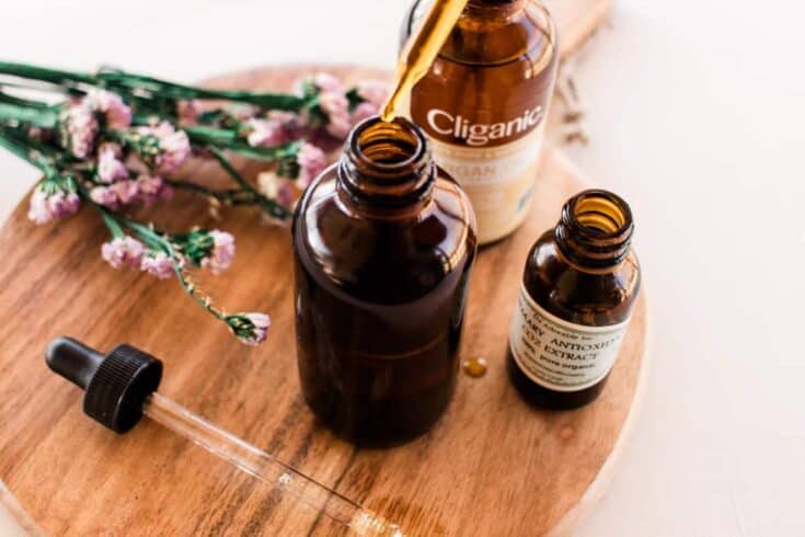 Using a dropper to add oil to a cleanser bottle.