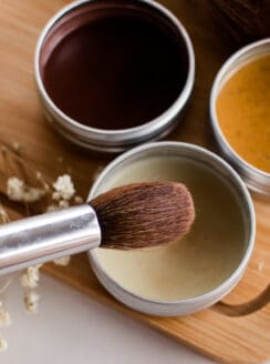 Dipping a makeup brush into a DIY highlighter recipe.