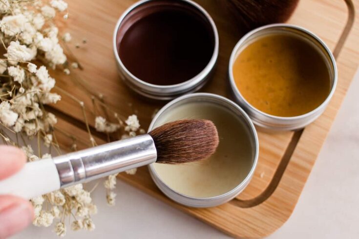 Dipping a makeup brush into a DIY highlighter recipe.