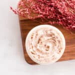 Tinted moisturizer in a glass jar with red flowers.